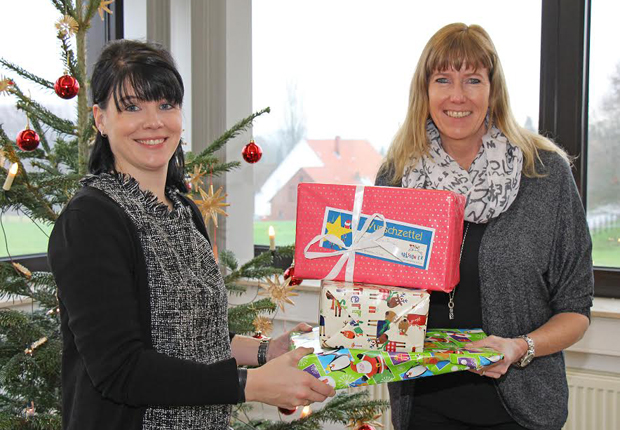 Kleidung und Schuhe, Kosmetik und Schmuck, Bücher, CDs und Spielzeug: Petra Imort (rechts) von Karlsson e. V. nahm die 108 Weihnachtsgeschenke von Vanessa Reimann (links), Marketingassistentin der Buschjost GmbH, entgegen. (Foto: Buschjost GmbH)