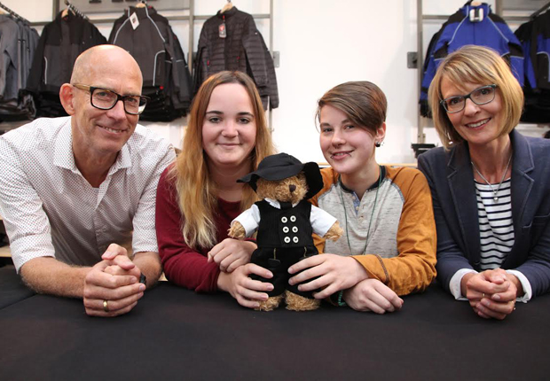 FHB-Chef Peter Hoffmann (von links) begrüßte gestern Lena Pahl aus Spenge und Anna Stegink aus Herford als erste Auszubildende im Beruf der Textil- und Modenäherin. Ausbilderin Kerstin Trippler (rechts) erläuterte an der Kleidung für den zünftigen FHB-Teddy Eddy (vorne), worauf es beim Nähen ankommt. (Foto: FHB original)