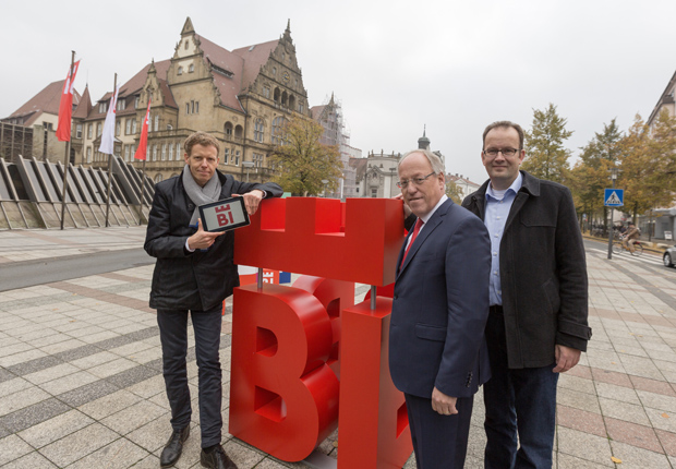 „Bielefelds Oberbürgermeister Pit Clausen (Mitte), Martin Knabenreich (r.), Geschäftsführer Bielefeld Marketing, und Marc Detering (l.), Geschäftsführer deteringdesign, stellten den neuen Markenauftritt der Stadt Bielefeld vor.“ (Foto: Björn Schmidt)