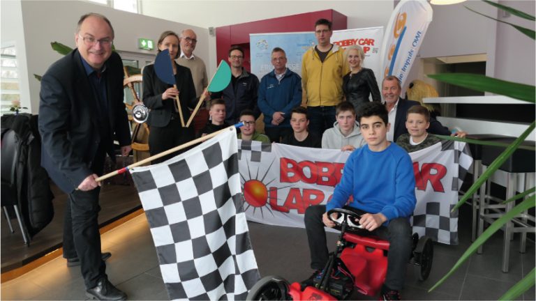 von l. n.r. Christian Kracht (Stadtwerke Bielefeld, Kooperationspartner und Juryvorsitzender), Andrea Wesemann (Agentur für Arbeit Paderborn), Rudolf Broer (GF RTB GmbH), Werner Reker, Ausbildungsleiter ELHA-Maschinenbau Liemke KG, Matthias Schmitt (Lehrer Gesamtschule Bad Lippspringe), Raik Möbius (Lehrer Franz-Stock-Realschule Hövelhof), Monika Pieper (Projektleitung Bobby Car Solar Cup), Klaus Meyer (VDI Verein Deutscher Ingenieure), Schüler vorne vl. nr. Gesamtschule Bad Lippspringe Aries Kastdorf, Jonah Wiesner, Franz-Stock Realschule: Max Pachur, Jonas Leuschner, Collin Vullhorst, auf dem Bobby Car: Gesamtschule Bad Lippspringe, Anas Elbundji. - Foto: Energie Impuls OWL