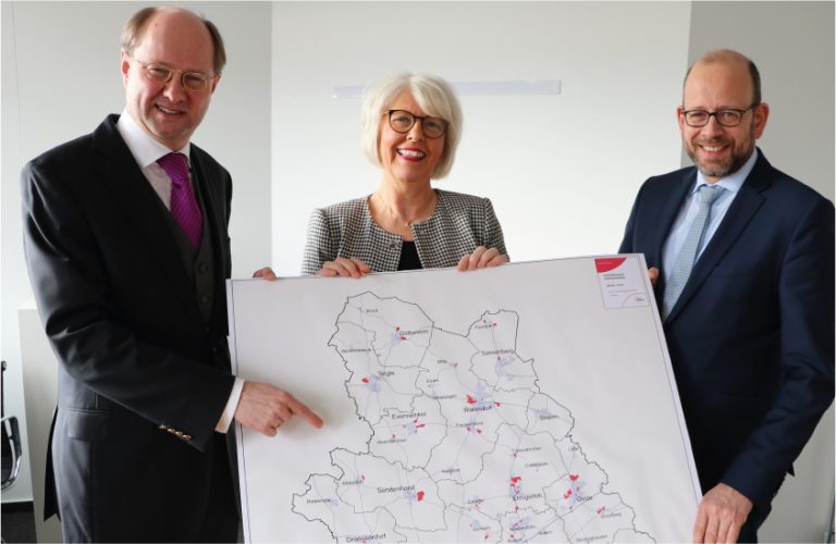 Mit einem neuen Förderprojekt sollen 90 weitere Gewerbegebiete (rot markiert) im Kreis Warendorf schnelle Glasfaseranschlüsse erhalten. Landrat Dr. Olaf Gericke, gfw-Geschäftsführerin Petra Michalczak-Hülsmann und Planungsdezernent Dr. Herbert Bleicher (von links) erläuterten den Förderantrag, der im Planungsausschuss beraten werden soll. - Foto: Kreis Warendorf