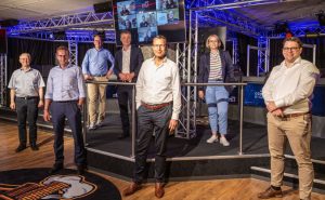 Gewinner OSNAHACK - Die Jury mit dem online zugeschalteten Gewinnerteam PACKOSEL: (V.l.) Prof. Dr.-Ing. Clemens Westerkamp (Hochschule Osnabrück), Heinz-Werner Hölscher (Geschäftsführer SWO Netz), Stefan Muhle (Staatssekretär für Digitalisierung im Nds. Wirtschaftsministerium), Ralf Minning (Geschäftsführer WFO), Marc Liepe (Vorstandsvorsitzender LM IT Services), Katharina Pötter (Vorstand Soziales und Bürgerservice Stadt Osnabrück) und Florian Stöhr (Geschäftsführer Seedhouse). © SWO Netz / René von der Haar)