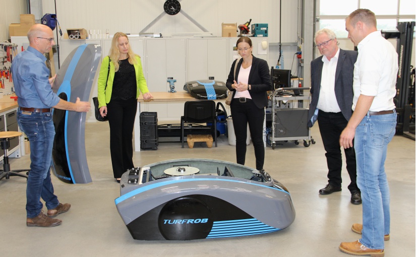 Den kundenbeauftragten Kunstrasen-Pflegeroboter Turfrob stellten die KonPro-Inhaber Stefan Mosel (links) und Jochen Wiechert (rechts) in der neuen Halle der Landrätin Anna Kebschull, Bürgermeisterin Tanja Strotmann und WIGOS-Geschäftsführer Siegfried Averhage vor. Foto: Petra Ropers