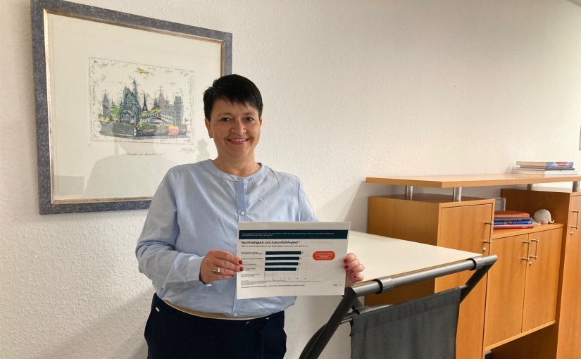 Simone Putsch, Niederlassungsleiterin Firmenkunden Bielefeld, mit einem Ausdruck der Studie „Wirtschaft im Umbruch: Die Chancen des Green Deal“. - Foto: Commerzbank