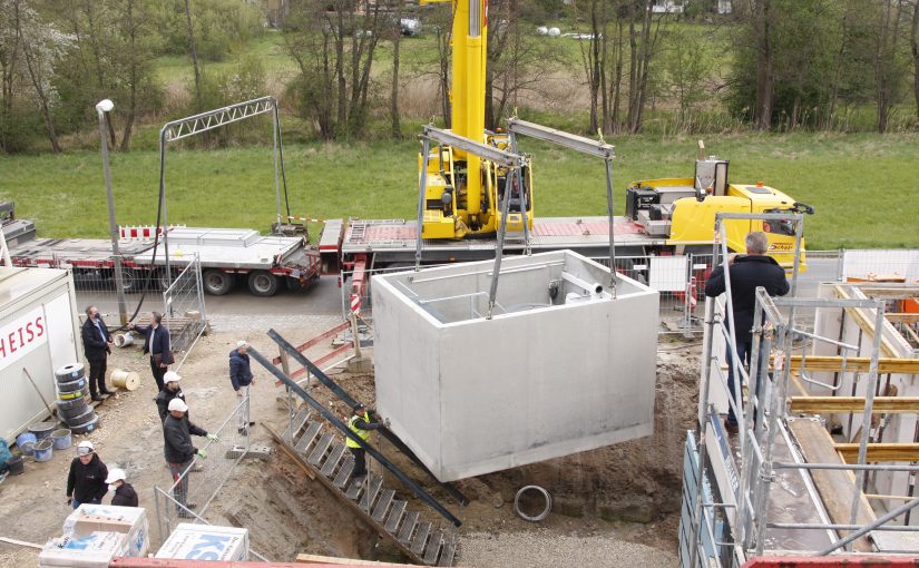 Vom Lkw ins Erdreich: Nur 20 Minuten dauerte die Einbringung der vorbestückten Heizzentrale für 13 Häuser.(Foto: August Brötje GmbH, Rastede)