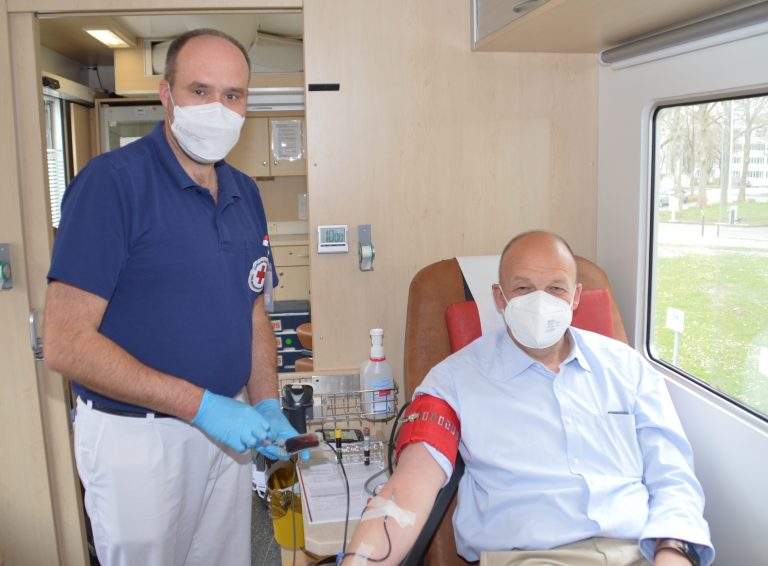 Jobcenter-Vorstand Stefan Susat (links) wird von DRK-Teamleiter Jan Ellerbrok fachgerecht „zur Ader gelassen“. (Foto: Jobcenter Lippe)