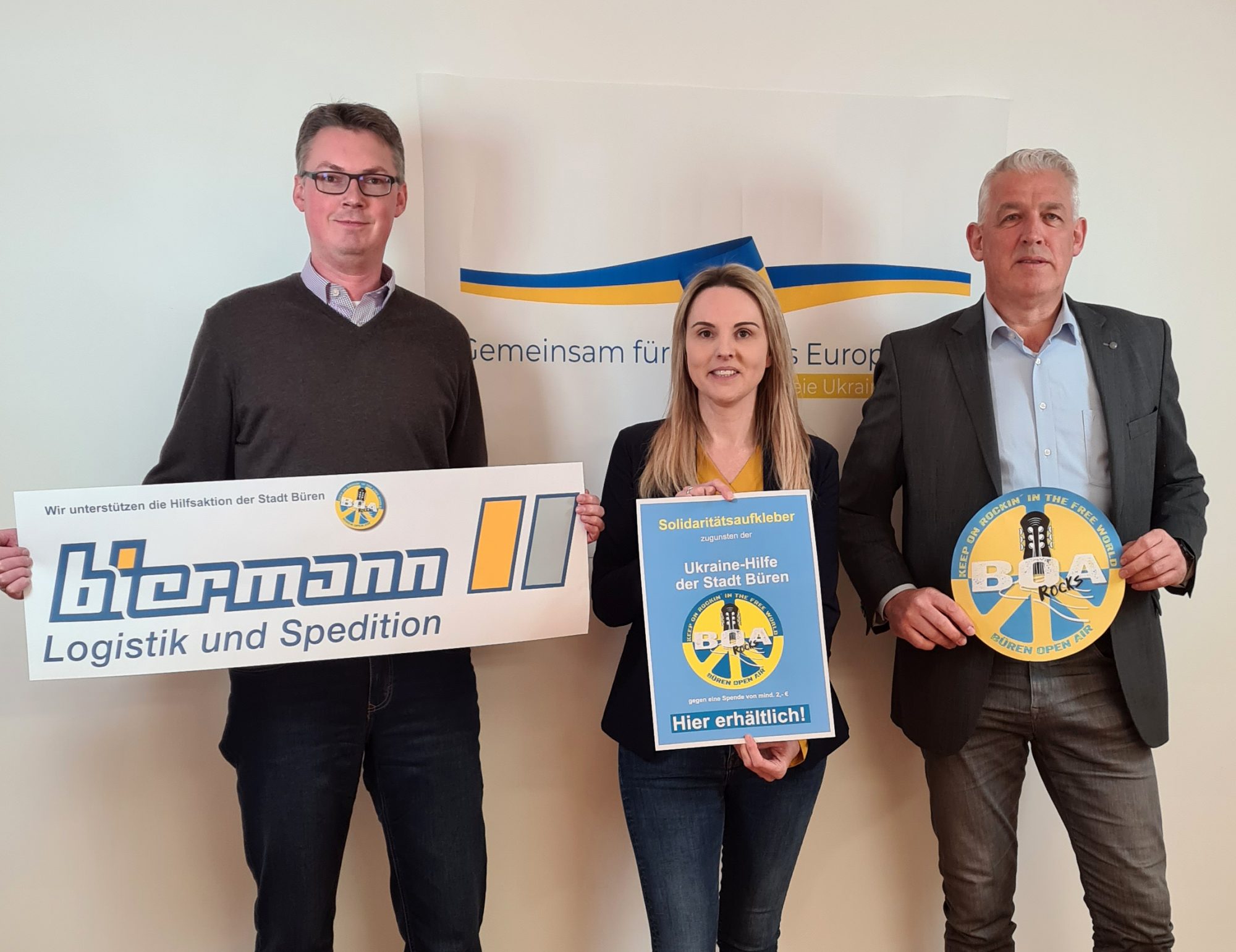 Friedel Biermann (Biermann Logistik und Spedition), Anke Hammerström (Stadtmarketing) und Wigbert Löper (Ortsvorsteher Büren) hoffen, dass die Aufkleber als Zeichen der Solidari-tät und als Symbol der verbindenden Wirkung von Musik auch in schwierigen Zeiten von vie-len wahrgenommen werden. (Foto: Stadt Büren)