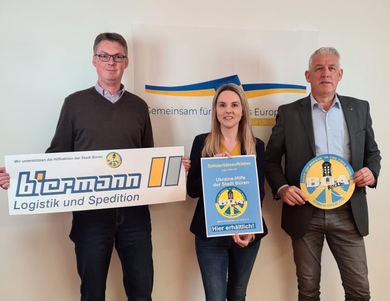 Friedel Biermann (Biermann Logistik und Spedition), Anke Hammerström (Stadtmarketing) und Wigbert Löper (Ortsvorsteher Büren) hoffen, dass die Aufkleber als Zeichen der Solidari-tät und als Symbol der verbindenden Wirkung von Musik auch in schwierigen Zeiten von vie-len wahrgenommen werden. (Foto: Stadt Büren)