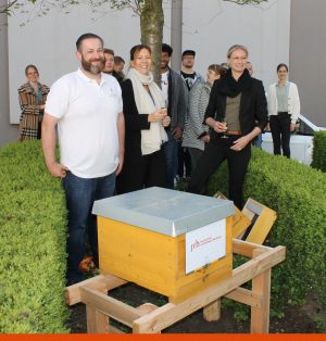 Imker Frederik Idem von beefuture (links), Dr. Jane Gleißberg, Nachhaltigkeitsmanagerin der SRH (Mitte) und Prof. Dr. Sabrina Krauss, Campusleitung des SRH Campus Rheinland, stellten den Bienenstock gemeinsam mit Nachbarn und Studierenden an der SRH auf. (Foto: SRH)
