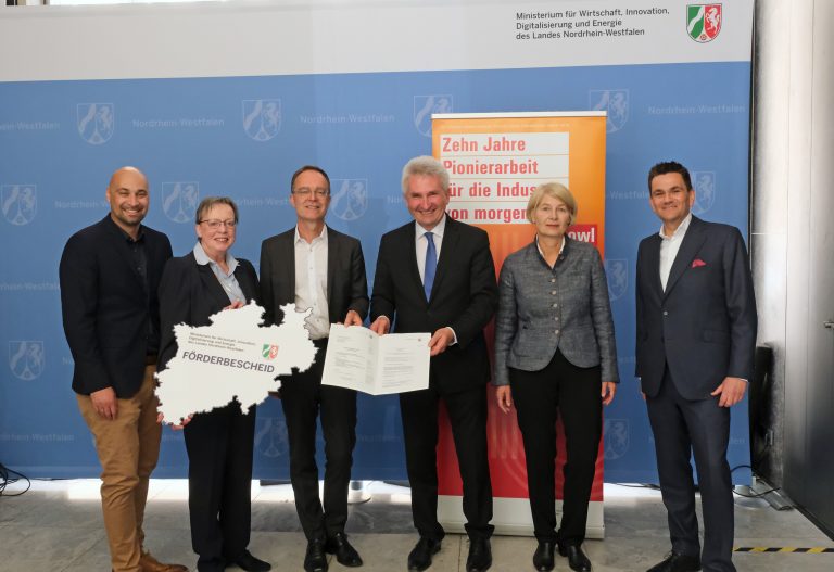 Bei der Übergabe der Fördermittelbescheide in Düsseldorf: NRW-Minister Prof. Dr. Andreas Pinkwart (5. von links), Regierungspräsidentin Marianne Thomann-Stahl (6. von links), Landrat Christoph Rüther (3. von links) und Flughafen-Geschäftsführer Roland Hüser (7. von links) mit den Beteiligten und Projektpartnern. (Foto: MWIDE NRW.)