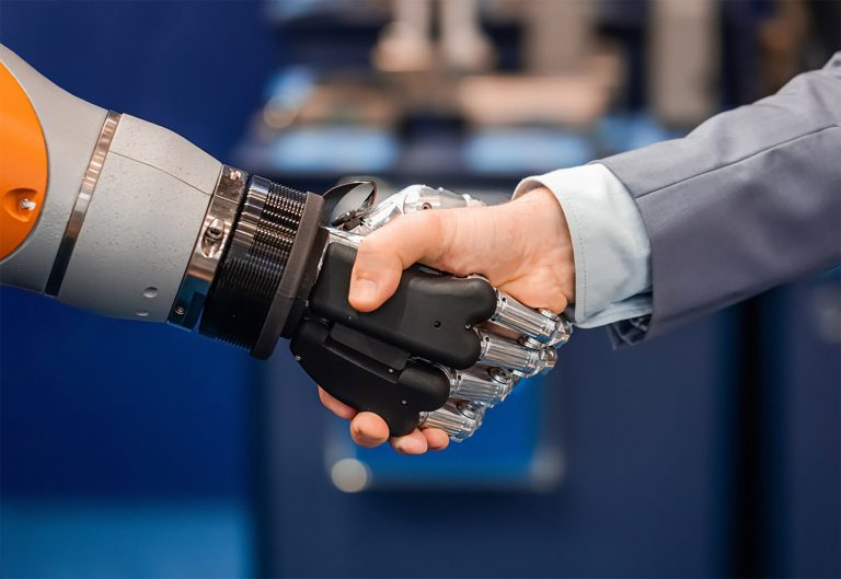 Das Technologiescouting unterstützt Unternehmen bei technologischen Entwicklungen und hilft ihnen, neue Technologien und deren Potenzial möglichst schnell zu erkennen. Roboter und Mensch schütteln sich die Hände (Foto: iStock/goldmarie design)