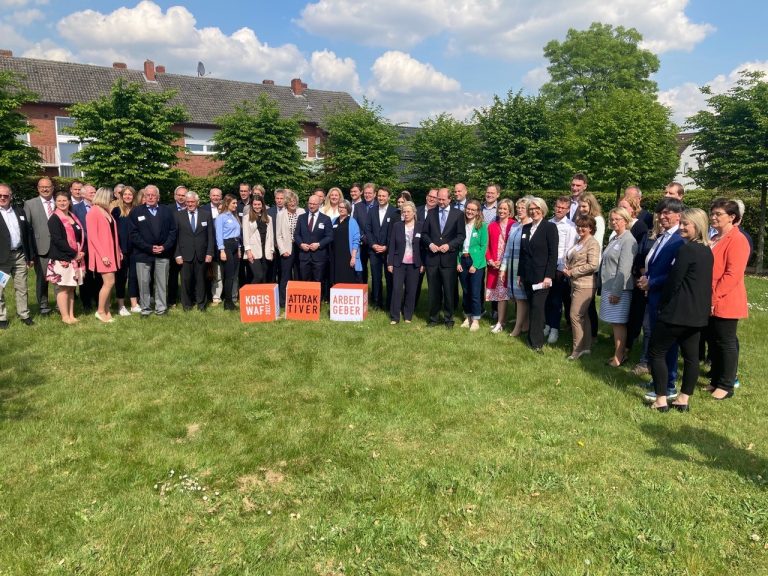 Ausgezeichnete Arbeitgeber, Landrat und Bürgermeister auf der grünen Wiese am Warendorfer Sparkassenforum vor der offiziellen Prämierung des gfw-Wettbewerbs „Attraktiver Arbeitgeber im Kreis Warendorf 2022“. (Foto: gfw)