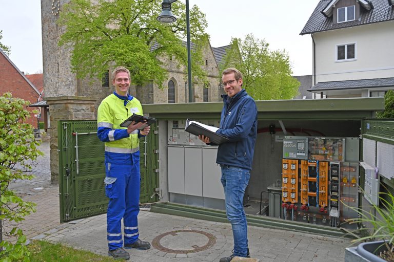 Assetmanager Christian Reeker und André Konermann, Meister Arbeitsvorbereitung und Netz-Digitalisierung, sind mit Ortsnetzstationen wie der am Hotel Sasse in Dreierwalde sehr zufrieden. Die Anlage gehört zu den am besten bewerteten Stationen im iNA-Projekt. (Foto: SWTE Netz GmbH & Co. KG)