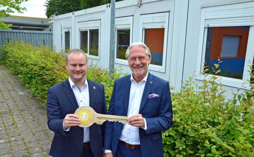 Jürgen Stühmeyer (rechts), Vorstand Merkur Vertrieb, übergibt den symbolischen Schlüssel für die Wohncontainer im Hintergrund an Espelkamps Bürgermeister Dr. Henning Vieker. (Foto: Gauselmann Gruppe)
