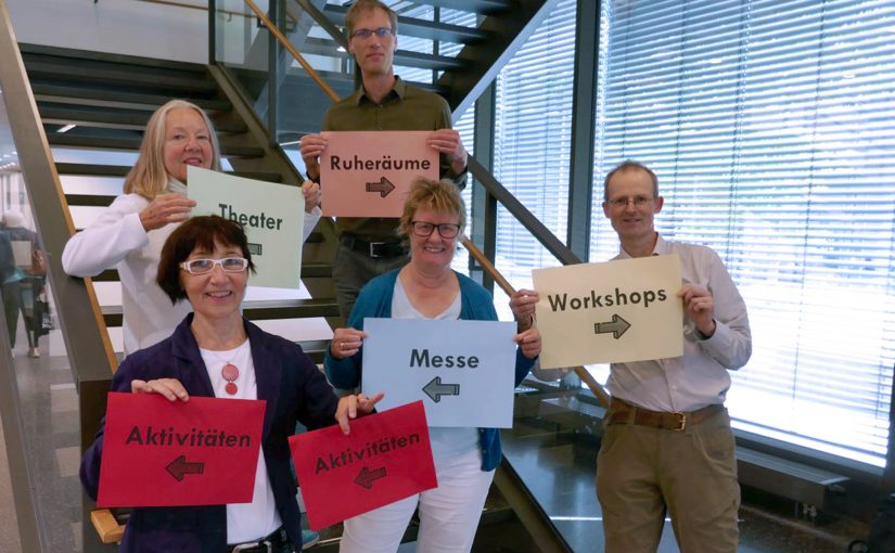 Präsentation des von Studierenden entwickelten Leitsystems zur Orientierung während des Fach- und Messetages: Dr. Eva Maria Schepers (Leitung des Westf. Instituts für Entwicklungsförderung) und Prof. Dr. Christian Huppert (FH Bielefeld) (hinten) mit Christiane Möcker (Mitarbeiterin des Planungsteams), Vera Trocha (Rehakoordinatorin, Fortbildungsakademie der Wirtschaft (FAW) gGmbH) und Markus Schneider (Autismus OWL e.V.) (Foto FH Bielefeld)