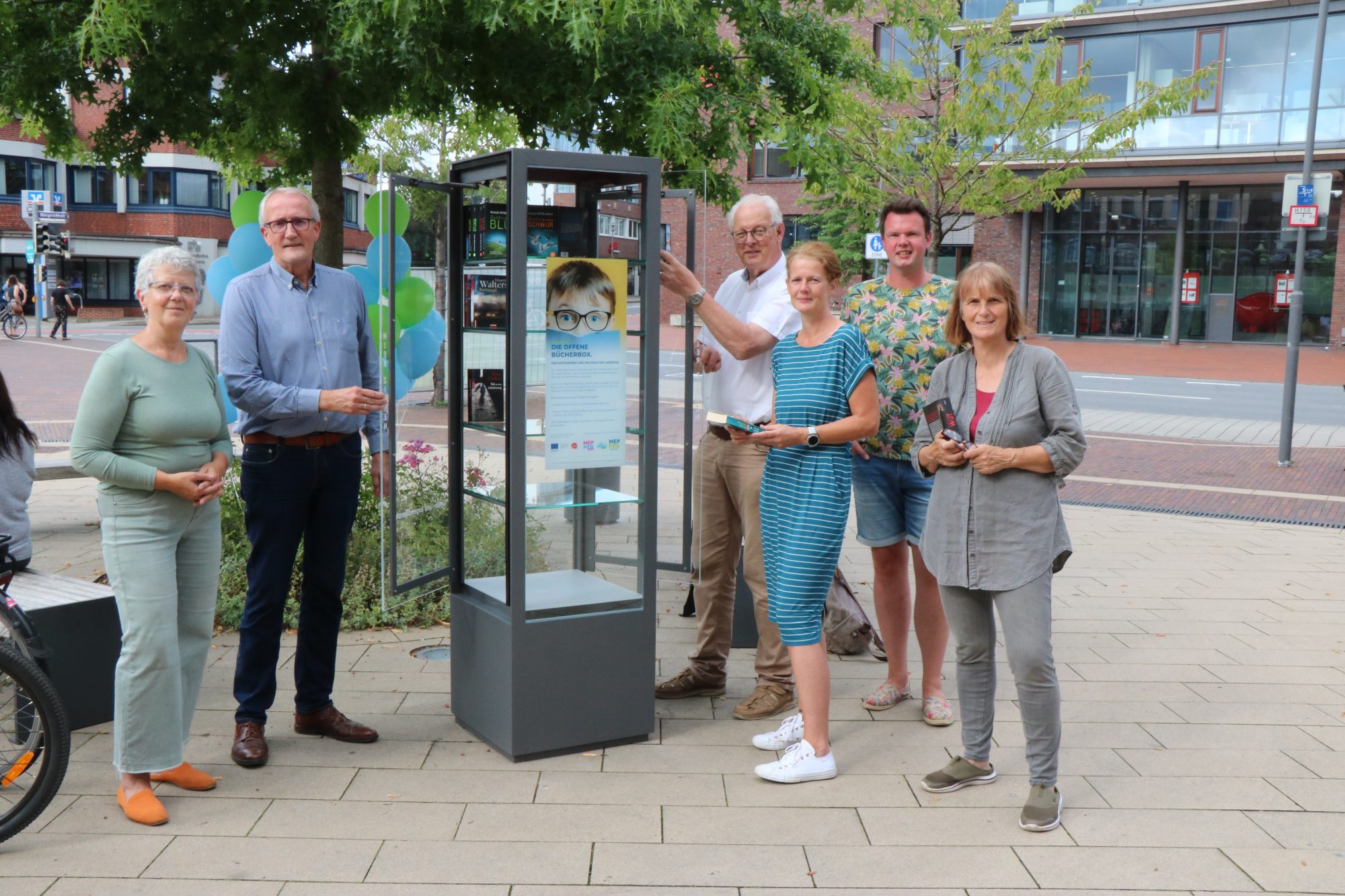 Zusammen mit dem Ersten Stadtrat Bernhard Ostermann haben Mitglieder der Fairtrade-Steuerungsgruppe der Stadt Meppen die ersten Bücher zur Weitergabe in die Offene Bücherbox auf dem Windthorstplatz eingestellt. (Foto: Stadt Meppen)