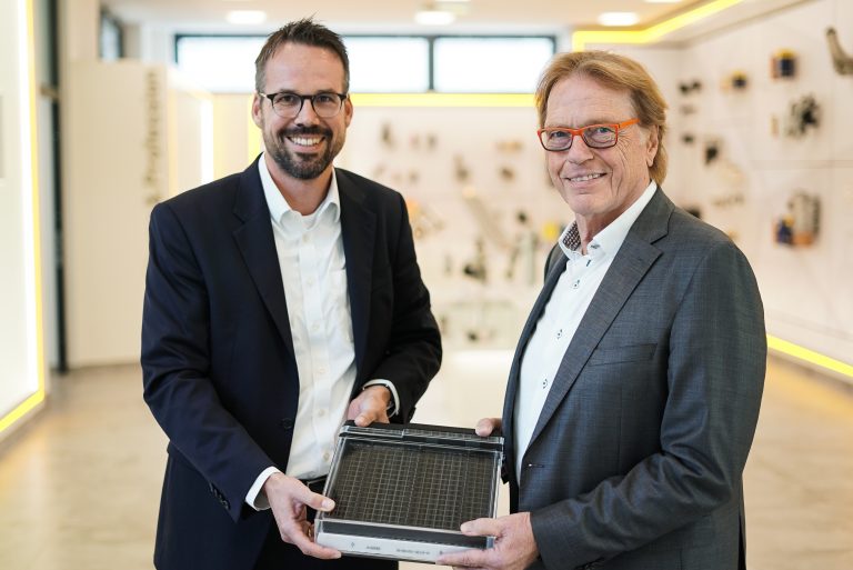 Christopher Heine (CEO Hengst SE) und Klaus Dieter Frers (Geschäftsführer, Gründer und Hauptaktionär von paragon GmbH & Co. KGaA) mit dem neuartigen elektrifizierten Innenraumfilter. (Foto: Hengst SE)