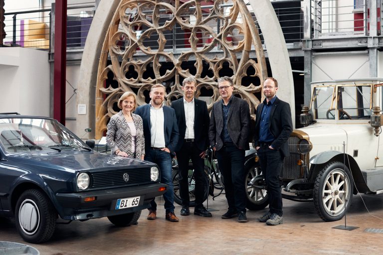 (v.l.n.r.) Hildegard Schumacher-Grub, Prof. Dr. Jens Haubrock, Dekan Prof. Dr. Rolf Naumann, Leiter des Historischen Museums Dr. Wilhelm Stratmann und wissenschaftlicher Mitarbeiter Kersten Kröger vor dem „neuen Exponat“ im Historischen Museum Bielefeld. (Foto: Pollmeier / FH Bielefeld)