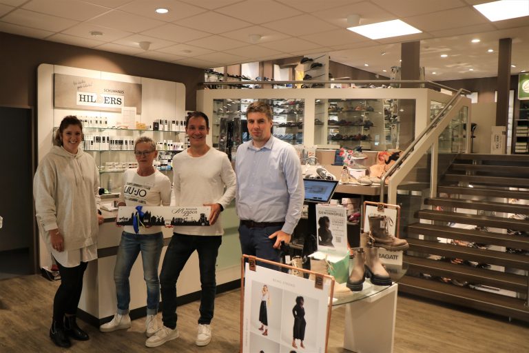 Wirtschaftsförderer Alexander Kassner (rechts) und Citymanagerin Janine Wester (links) gratulierten dem stellvertretenden Geschäftsführer Michael Reusch (2. v. r.) und Filialleiterin Brigitte Peters (2. v. l.) zum 30-jährigen Standortjubiläum und überreichten als Geschenk die „Meppener Skyline“. (Foto: Stadt Meppen)