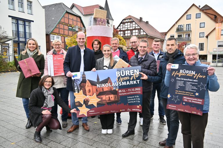 Vordere Reihe: Isabel Schulte (Stadtmarketing), Benedikt Stiewe (Volksbank Büren-Salzkotten), Julia Snelinski (Westenergie), Dirk Herbst (Sparkasse Paderborn-Detmold), Bürgermeister Burkhard Schwuchow und Ingrid Bischof (Speisenkammer). Hintere Reihe: Anke Hammerstöm (Stadtmarketing), Gemeindereferentin Daniela Reineke, Barbara Diederichs (Elektro Lüke), Martin Stich (Bock auf Büren), Manuel Krenz (Abteilungsleiter Bürgerdienste) und Patrick Dietz (Marktkauf Büren). Nicht im Bild: Ingrid Lutter (Reit- und Fahrverein). Der Nikolausstiefel im Hintergrund steht ab sofort im Marktkauf für Spenden bereit. (Foto: Stadt Büren)