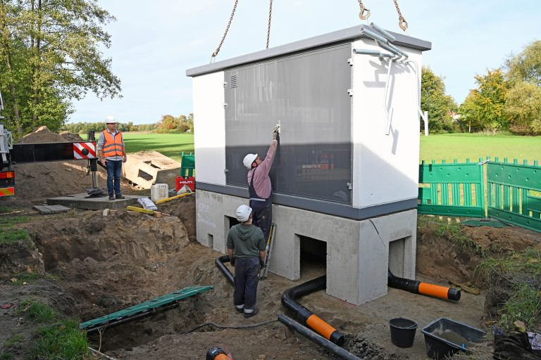 Oliver Deutsch (l.), Leiter Netzbetrieb Erdgas, verfolgt das Aufstellen der neuen Gasdruckregelanlage. Sowohl das Betonfundament als auch die Anlage mitsamt Leitungen und Reglern wurden bau-fertig angeliefert. (Foto: SWTE)