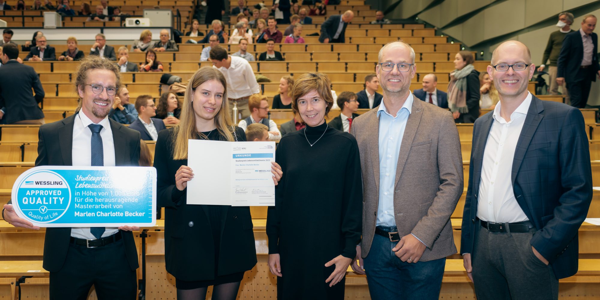 (V.l.) Dr. Henning Kuchenbuch vom Unternehmen WESSLING gratuliert Marlen Becker zusammen mit Prof. Dr. Melanie Esselen, Dr. Benedikt Cramer und Prof. Dr. Frank Glorius zu ihrer herausragenden Masterarbeit im Fachbereich Lebensmittelchemie. (Foto: Peter Dziemba, WWU)