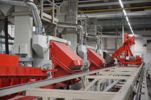 Drei AGTOS Trommel-Strahlanlagen im automatisierten Prozess. (Foto: AGTOS)