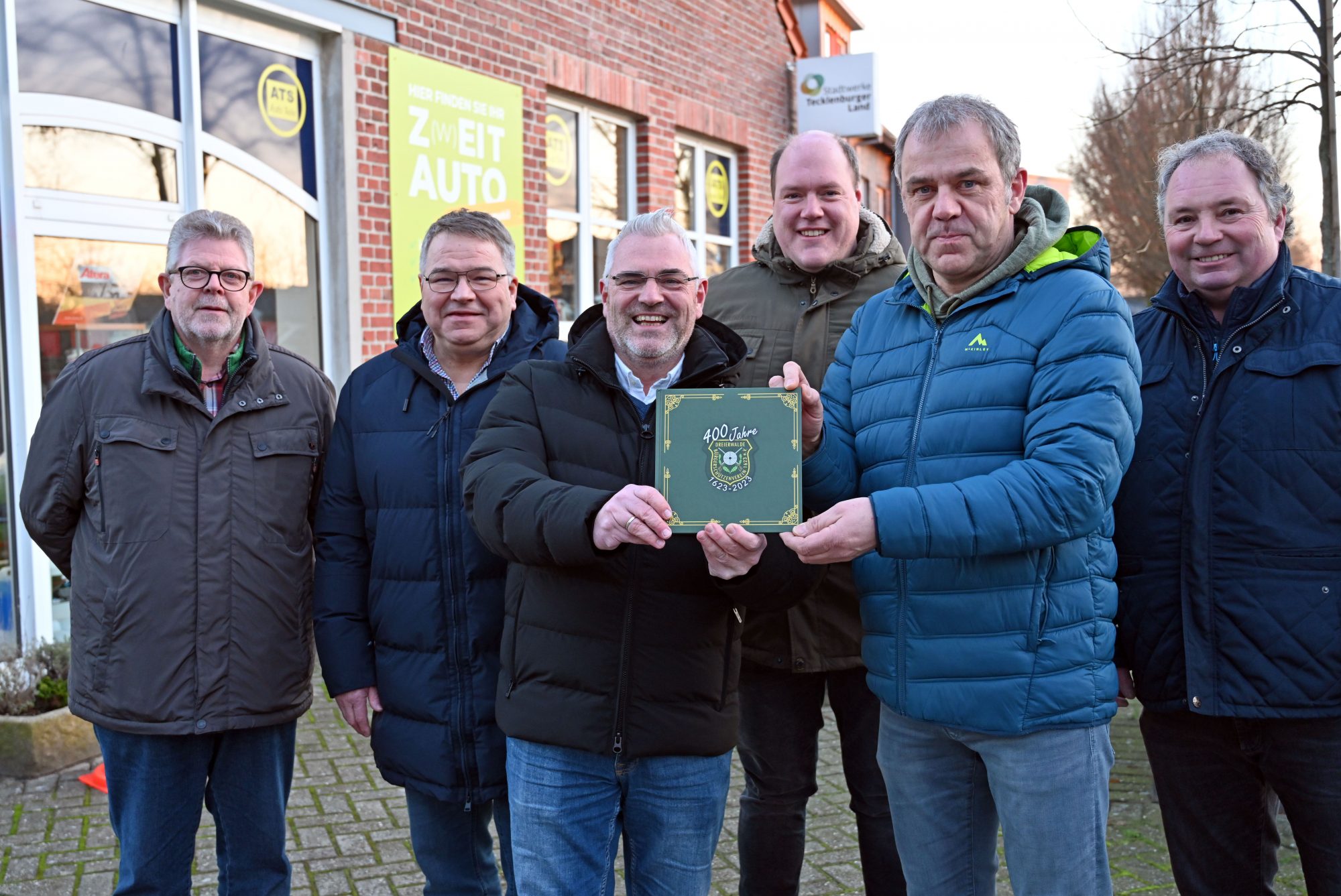 Marcus Rüdiger (3.v.l.) und Vorsitzender Michael Winnemöller (2.v.r.) präsentieren das Multime-dia-Jubiläumsbuch. Klaus Niehues (r.), Ralf Wolters (v.l.), Tobias Sommer und Stefan Lütkemeier freuen sich über die Spende der Stadtwerke Tecklenburger Land. (Foto: Stadtwerke Tecklenburger Land / Vera Konermann)