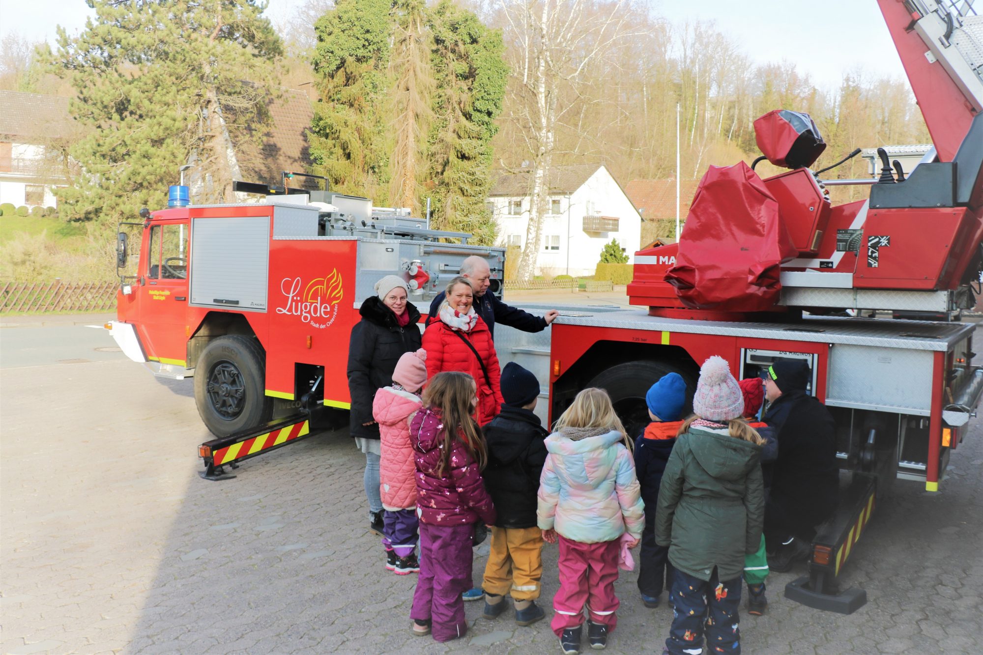 V. li.: Der Leiterwagen sorgte für besondere Freude bei den Kleinen und auch die Erzieherinnen Nicole Müller und Christina Schaper hatten viel Spaß bei der Vorführung von Dirk Köchling und Maik Paskarbeit von der Freiwilligen Feuerwehr Lügde. (Foto: Johanniter-Unfall-Hilfe e.V.)