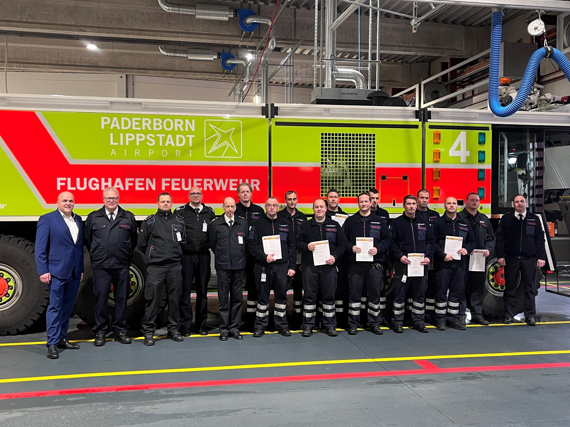 Flughafen-Geschäftsführer Roland Hüser, Kreisbrandmeister Elmar Keuter, Leitstellen-Leiter Tobias Starke, Rettungsdienst-Leiter Stefan Kaiser und der Ärztliche Leiter des Rettungsdienstes Ingo Christiansen (von links) gratulieren einigen Teilnehmern mit dem Leiter der Flughafen-Feuerwehr Roland Kempkensteffen (rechts) zur erfolgreichen Ausbildung als Notfallhelfer NRW. (Foto: Flughafen Paderborn / Lippstadt)
