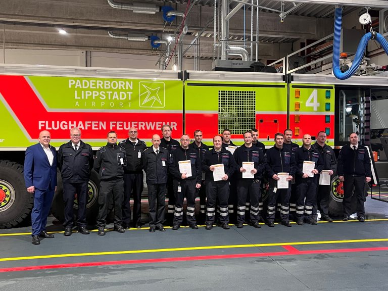 Flughafen-Geschäftsführer Roland Hüser, Kreisbrandmeister Elmar Keuter, Leitstellen-Leiter Tobias Starke, Rettungsdienst-Leiter Stefan Kaiser und der Ärztliche Leiter des Rettungsdienstes Ingo Christiansen (von links) gratulieren einigen Teilnehmern mit dem Leiter der Flughafen-Feuerwehr Roland Kempkensteffen (rechts) zur erfolgreichen Ausbildung als Notfallhelfer NRW. (Foto: Flughafen Paderborn / Lippstadt)