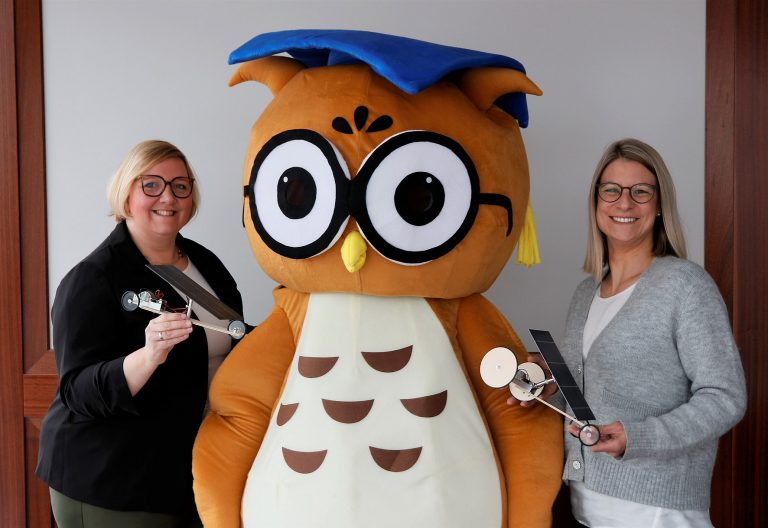 Katja Bohne und Maleen Glockzin (von links) von der Dr. Jürgen und Irmgard Ulderup Stiftung freuen sich gemeinsam mit dem Maskottchen „Einstein“ auf das dritte Diepholzer Solarautorennen. (Foto: Ulderup-Stiftung)
