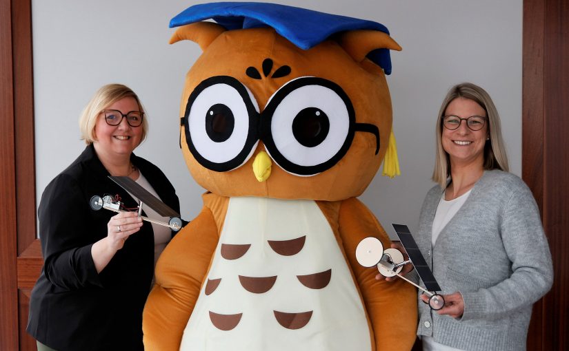 Katja Bohne und Maleen Glockzin (von links) von der Dr. Jürgen und Irmgard Ulderup Stiftung freuen sich gemeinsam mit dem Maskottchen „Einstein“ auf das dritte Diepholzer Solarautorennen. (Foto: Ulderup-Stiftung)