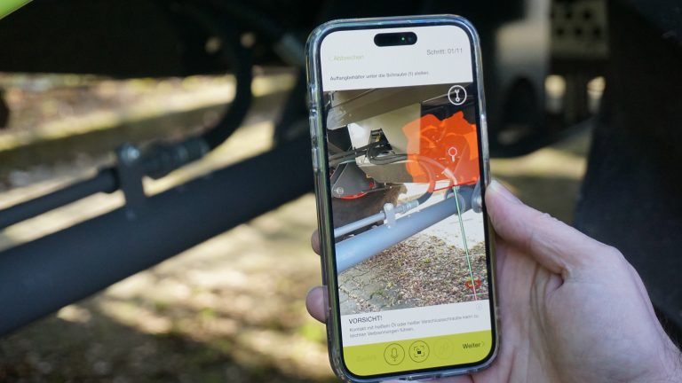 Mähdrescher-Wartung mit Augmented Reality: CLAAS erprobt den Einsatz von AR-Apps zur Unterstützung der Wartung komplexer Maschinen. Über ihre iPhones werden Service-Techniker:innen an die relevanten Stellen der Mähdrescher navigiert. (Foto: Fraunhofer IEM)