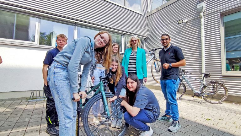 Frau Rehmann (Schulleiterin Gesamtschule Büren) und Herr Farke (Lehrer Gesamtschule Büren) mit Schülerinnen und Schülern beim Fahrrad-Check zum Auftakt des Schulradelns in Büren (Foto: Stadt Büren)