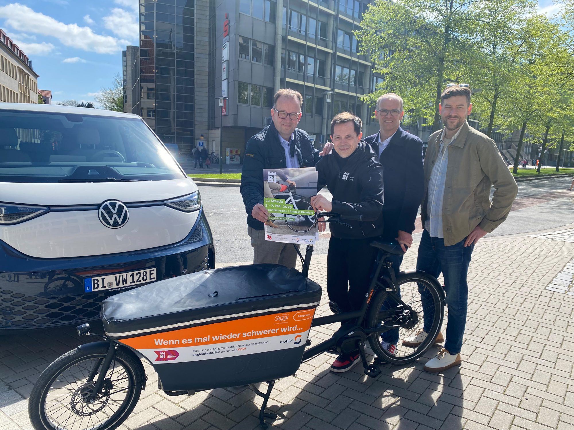 (v. l.) Martin Knabenreich und Jens Kramer (beide Bielefeld Marketing), Martin Uekmann (Stadtwerke Bielefeld) und Sebastian Wappelhorst (Eigenrauch & Partner) präsentieren am Niederwall das Programm für die La Strada 2023. Der Niederwall wird erstmals für den Verkehr gesperrt und als Fahrradteststrecke genutzt. (Foto: Bielefeld Marketing)