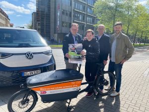 (v. l.) Martin Knabenreich und Jens Kramer (beide Bielefeld Marketing), Martin Uekmann (Stadtwerke Bielefeld) und Sebastian Wappelhorst (Eigenrauch & Partner) präsentieren am Niederwall das Programm für die La Strada 2023. Der Niederwall wird erstmals für den Verkehr gesperrt und als Fahrradteststrecke genutzt. (Foto: Bielefeld Marketing)