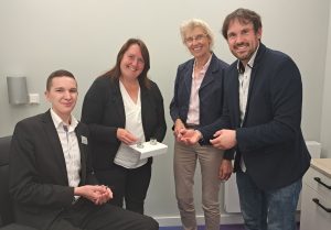 Er hat das perfekte Berufsfeld für sich gefunden: Hörgerä-teakustiker Christofer Macholla (links) erläutert gemeinsam mit Meisterin Kaya Harbaum-Salewski (2.v. links) Hildegard Hes-selbarth, ArbeitgeberService, und Michael Kelka, MaßArbeit-Bereichsleiter, die neuste Technik in Sachen Hörgeräte. (Foto: MaßArbeit / Kimberly Lübbersmann)