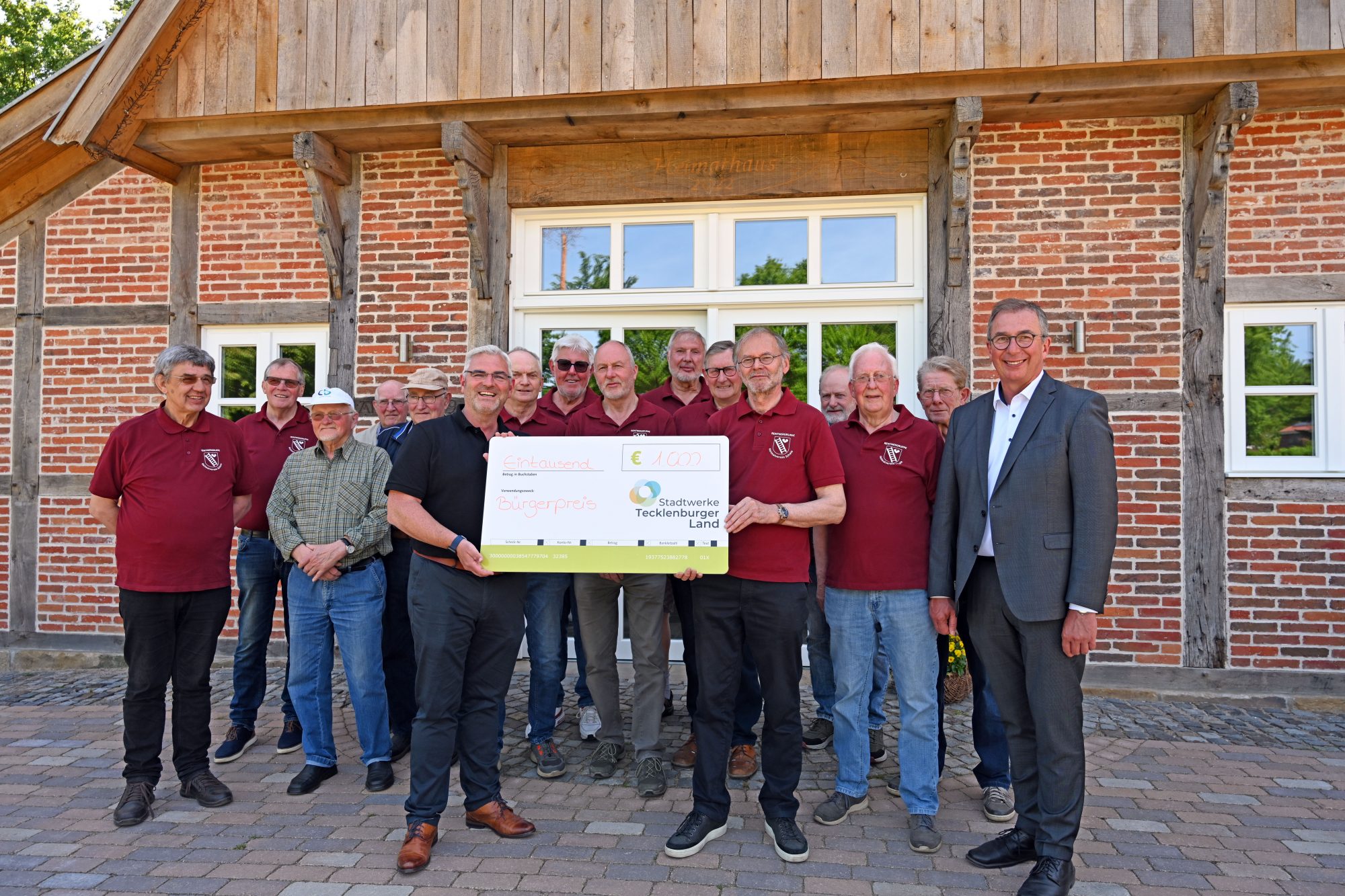 Reinhard Lömker (5.v.r.) nahm gemeinsam mit seinen Mitstreitern von der Rentnergruppe des Hei-matvereins Schale den symbolischen Scheck für das Preisgeld von Marcus Rüdiger (6.v.l.) in Emp-fang. Hopstens Bürgermeister Ludger Kleine-Harmeyer (r.) gratulierte und bedankte sich bei der Gruppe für deren Einsatz für den Ort. Foto: Stadtwerke Tecklenburger Land (Foto: SWTE)
