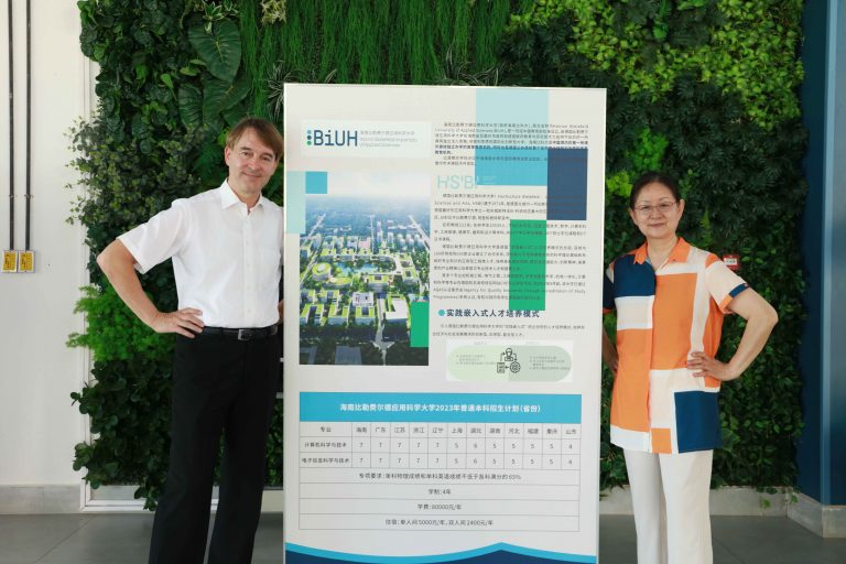 BiUH-Präsident Prof. Dr. Jürgen Kretschmann und Kanzlerin Prof. Dr. Guan Naijia vor einem Plakat mit dem Bauvorhaben für den Campus der neuen Hochschule. (Foto: Ziwei Du/BiUH)