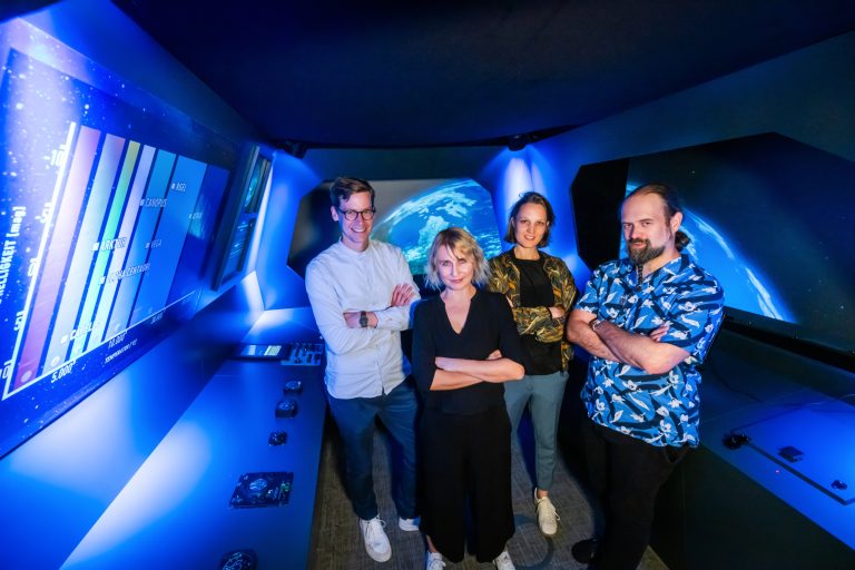 Im Cockpit: (v.r.) Dr. Matthias Schmidt-Rubart (Universität Bielefeld), Prof. Claudia Rohrmoser (Hochschule Bielefeld), Milla Lifke (Wissenswerkstadt Bielefeld) und Matthias Boerger (Volksbank Bielefeld-Gütersloh).“ (Foto: Wissenswerkstadt/ Sarah Jonek)