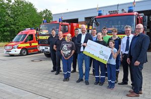 Stadtwerke-Geschäftsführer Christian Averdiek (5.v.l.) überreichte den symbolischen Scheck an die Kinder und Jugendlichen der Lotter Nachwuchsfeuerwehr. Es gratulierten der stellvertretende Bür-germeister Christian Thies (v.r.), Gerd Nüsse und Julian Brüggemann (l., beide Feuerwehr Lotte). (Foto: Stadtwerke Tecklenburger-Land)