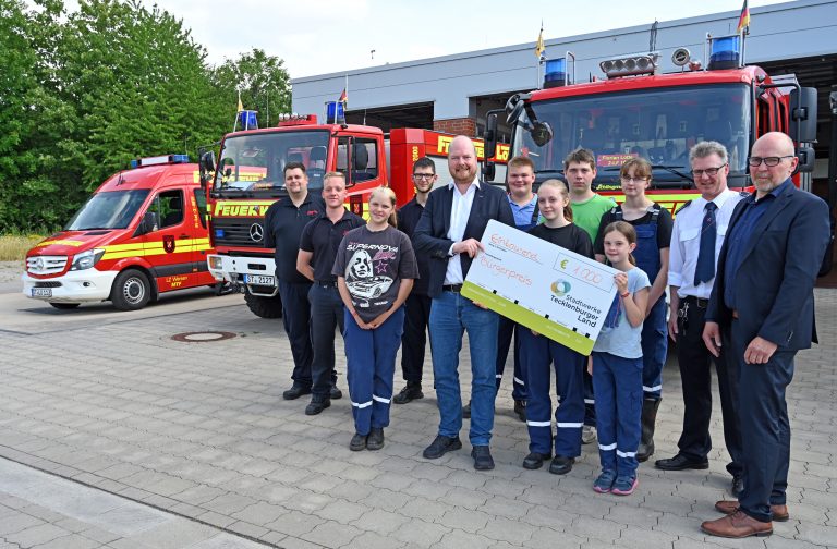 Stadtwerke-Geschäftsführer Christian Averdiek (5.v.l.) überreichte den symbolischen Scheck an die Kinder und Jugendlichen der Lotter Nachwuchsfeuerwehr. Es gratulierten der stellvertretende Bür-germeister Christian Thies (v.r.), Gerd Nüsse und Julian Brüggemann (l., beide Feuerwehr Lotte). (Foto: Stadtwerke Tecklenburger-Land)