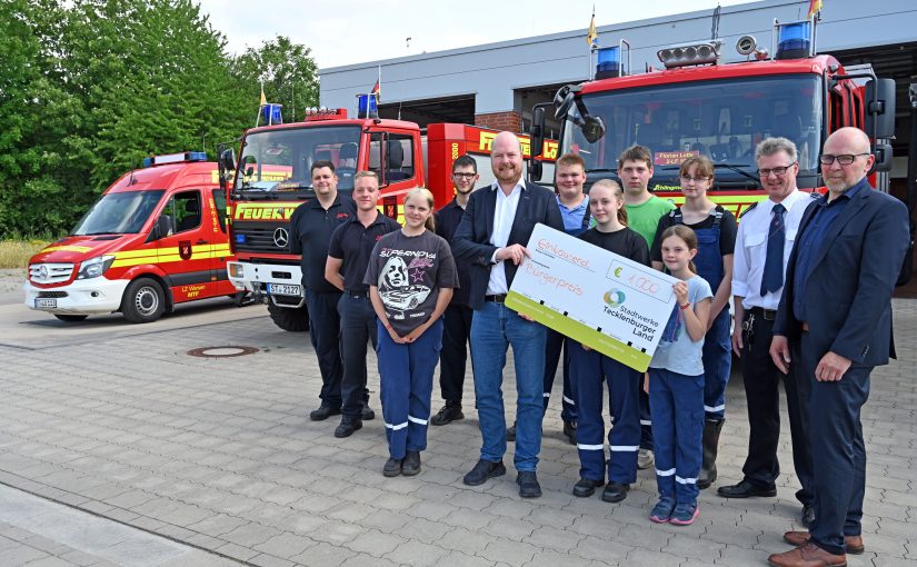 Stadtwerke-Geschäftsführer Christian Averdiek (5.v.l.) überreichte den symbolischen Scheck an die Kinder und Jugendlichen der Lotter Nachwuchsfeuerwehr. Es gratulierten der stellvertretende Bür-germeister Christian Thies (v.r.), Gerd Nüsse und Julian Brüggemann (l., beide Feuerwehr Lotte). (Foto: Stadtwerke Tecklenburger-Land)