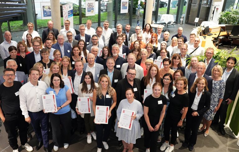 Vertreterinnen und Vertreter der 28 prämierten Unternehmen, der Jury und der Initiatoren des Wettbewerbs „Ausgezeichnet Familienfreundlich Bielefeld“ versammeln sich im Anschluss an die Feierstunde im Foyer der IHK Ostwestfalen zu Bielefeld (Bildnachweis: IHK Ostwestfalen zu Bielefeld)