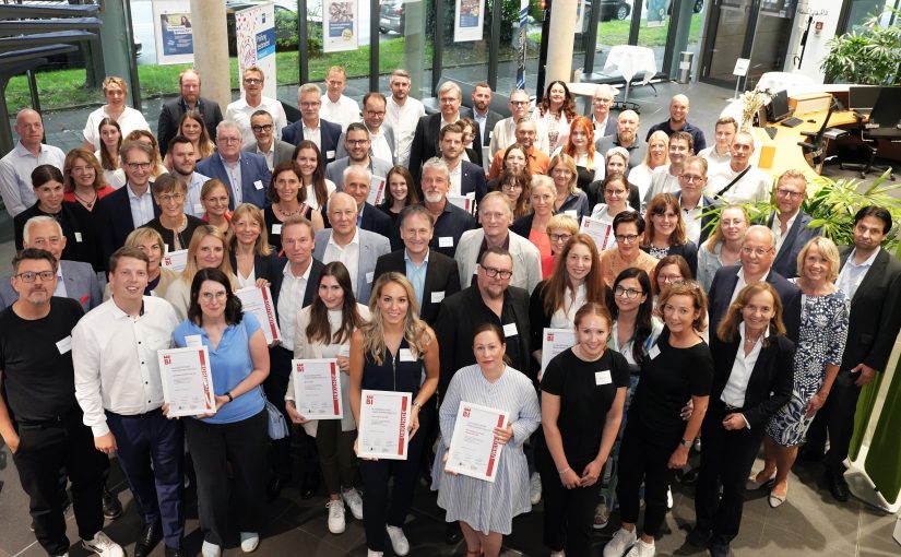 Vertreterinnen und Vertreter der 28 prämierten Unternehmen, der Jury und der Initiatoren des Wettbewerbs „Ausgezeichnet Familienfreundlich Bielefeld“ versammeln sich im Anschluss an die Feierstunde im Foyer der IHK Ostwestfalen zu Bielefeld (Bildnachweis: IHK Ostwestfalen zu Bielefeld)