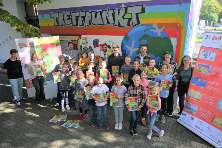 Viele Kinder und Jugendliche durften sich gemeinsam mit Bürgermeister Burkhard Schwuchow und den Mitarbeitenden der städtischen Jugendpflege, der Jugendarbeit, der Grundschulsozialarbeit und dem Jugendbeirat Büren anlässlich des Weltkindertages 2023 über ein Exemplar des Silent Books „Anders Gleich“ freuen. (Foto: Stadt Büren)