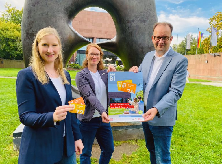 Im Skulpturenpark der Kunsthalle stellen Jacqueline Heger (v. l., Bielefeld Marketing), Friederike Langer (moBiel) und Martin Knabenreich (Bielefeld Marketing) die neue Entdecker-Karte für Bielefeld vor. (Foto: Bielefeld Marketing)