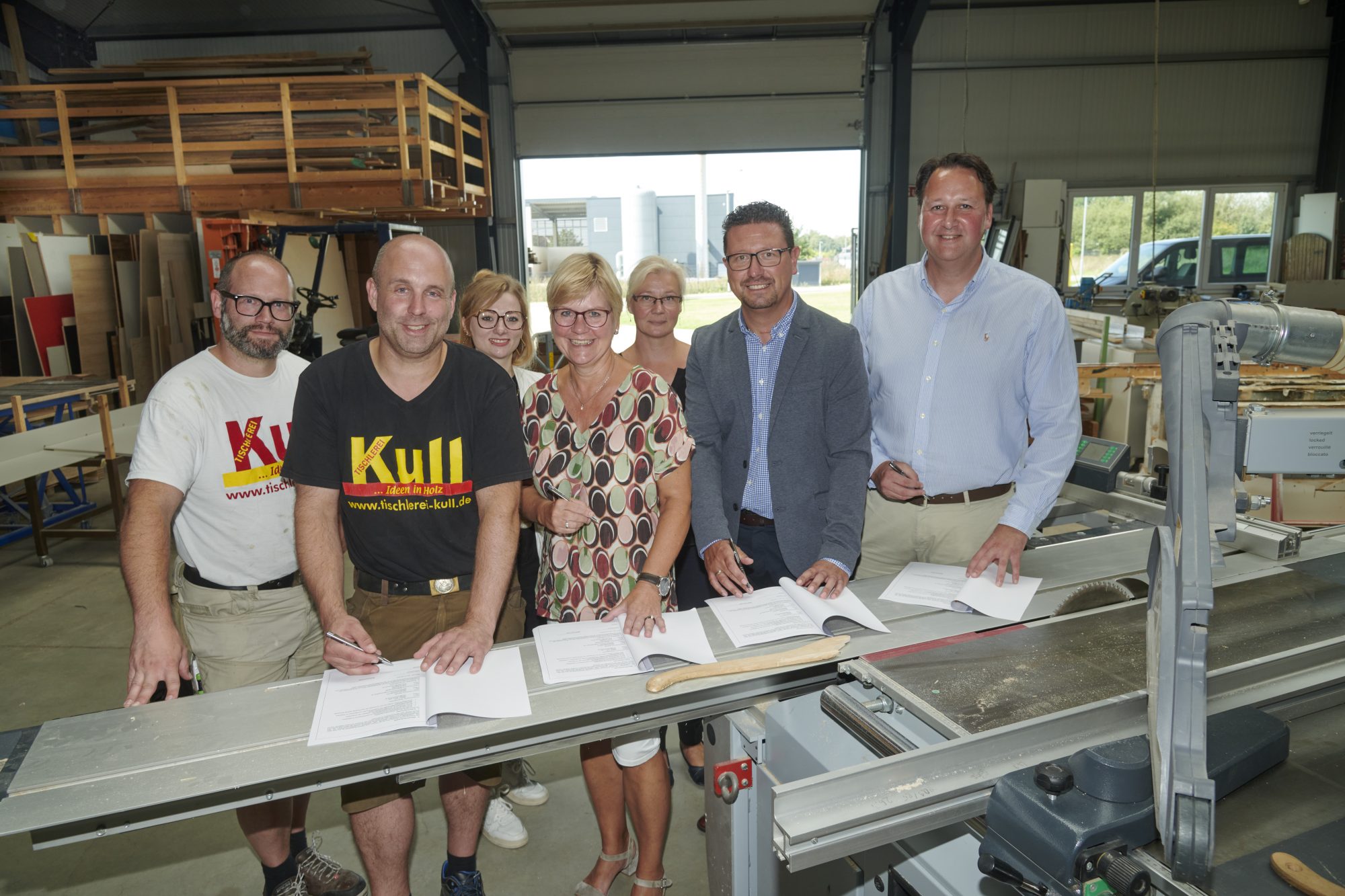 Sie besiegelten die neue Kooperation zwischen der Geschwis-ter-Scholl-Oberschule in Bad Laer und der Tischlerei Kull (von links): die Geschäftsführer Tobias und Markus Kull, Annika Schütte von der Servicestelle Schule-Wirtschaft, Schulleiterin Stefanie Baalmann, die Berufsorientierungsbeauftrage und Fachberaterin beim Regionalen Landesamt für Schulen und Bildung, Mareike Himmelreich, MaßArbeit-Vorstand Lars Hell-mers sowie Bürgermeister Tobias Avermann (Foto: MaßArbeit / Uwe Lewandowski)