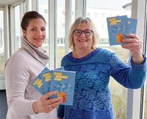 Nina Oesterreich (l., Kulturamt Bielefeld) und Marianne Weiß (Bielefeld Marketing) haben 7.500 „Bielefelder Kulturkalender 2024“ mit mehr als 300 Terminen fürs nächste Jahr drucken lassen. (Foto: Bielefeld Marketing)
